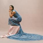 Victoria Canal crouching in a blue long dress that drapes onto the floor